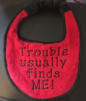 Adult bib in red with slogan"Trouble Usually Finds me"