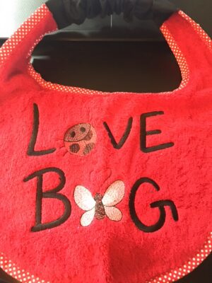 Adult Bib in red with slogan "Love Bug"